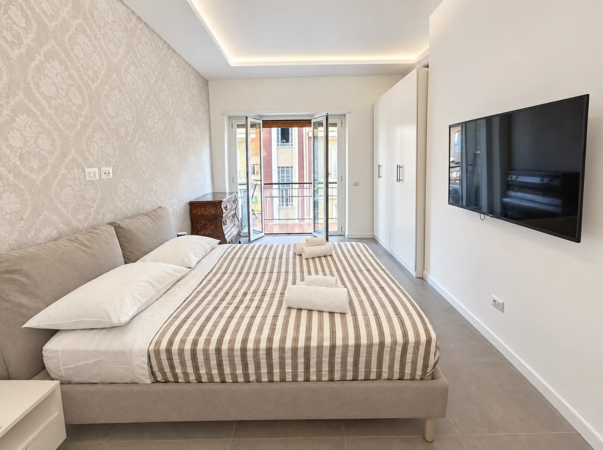 Camera tripla con letto matrimoniale, TV e portafinestra sul balcone