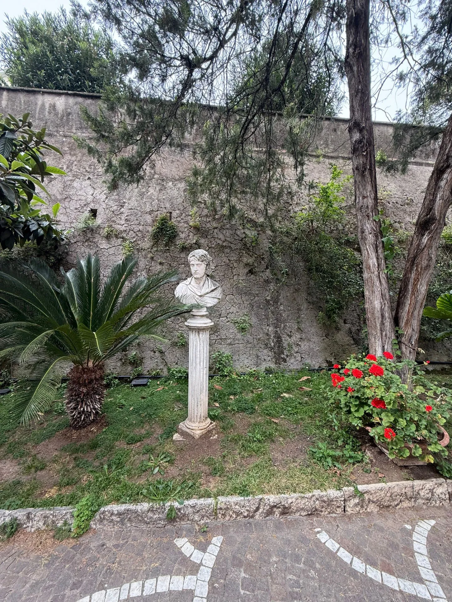 Giardino del cortile condominiale con busto in marmo su colonna